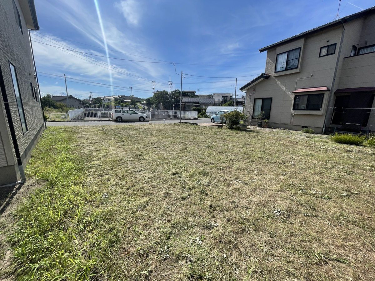 空き地の草刈り後：隣家側から見た区画全体。境界際まで刈り上げられた状態