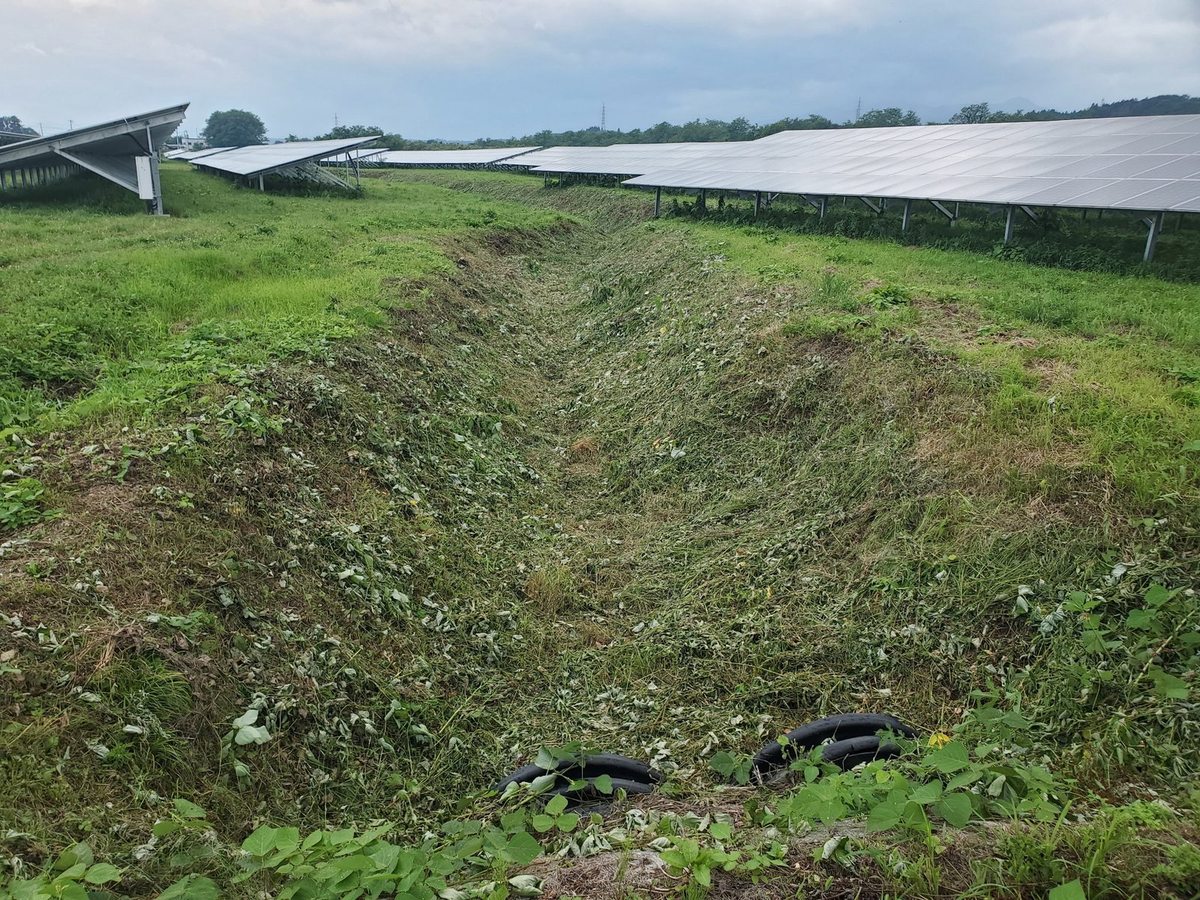 太陽光発電所の除草後：法面と排水路まで刈り込みすっきりした状態