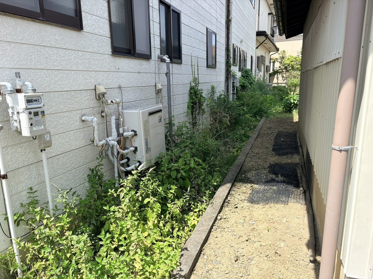 長野市の防草シート施工前:ガス給湯器側の通路に雑草が茂る状態