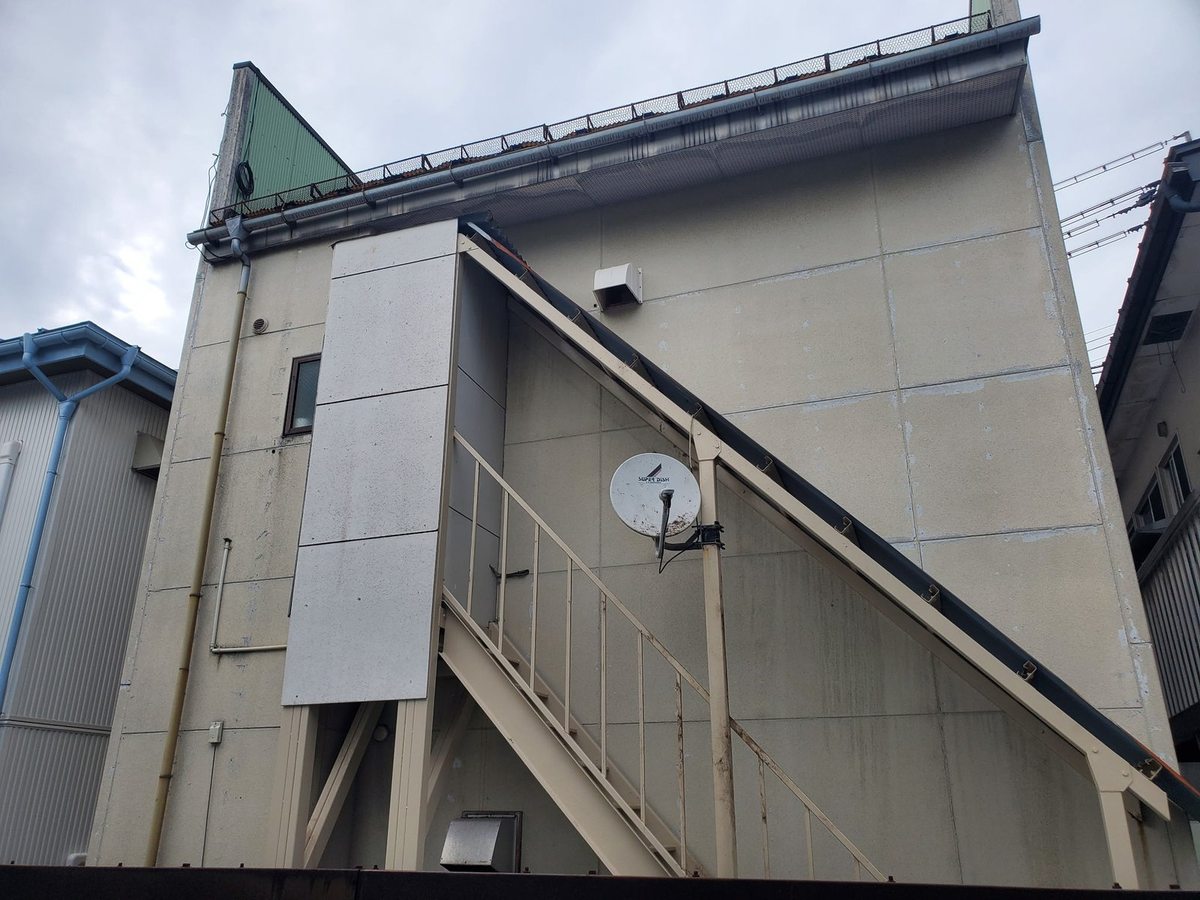 北上市の建物裏ツタ除去後:外階段と壁面のツタが撤去されすっきりした状態