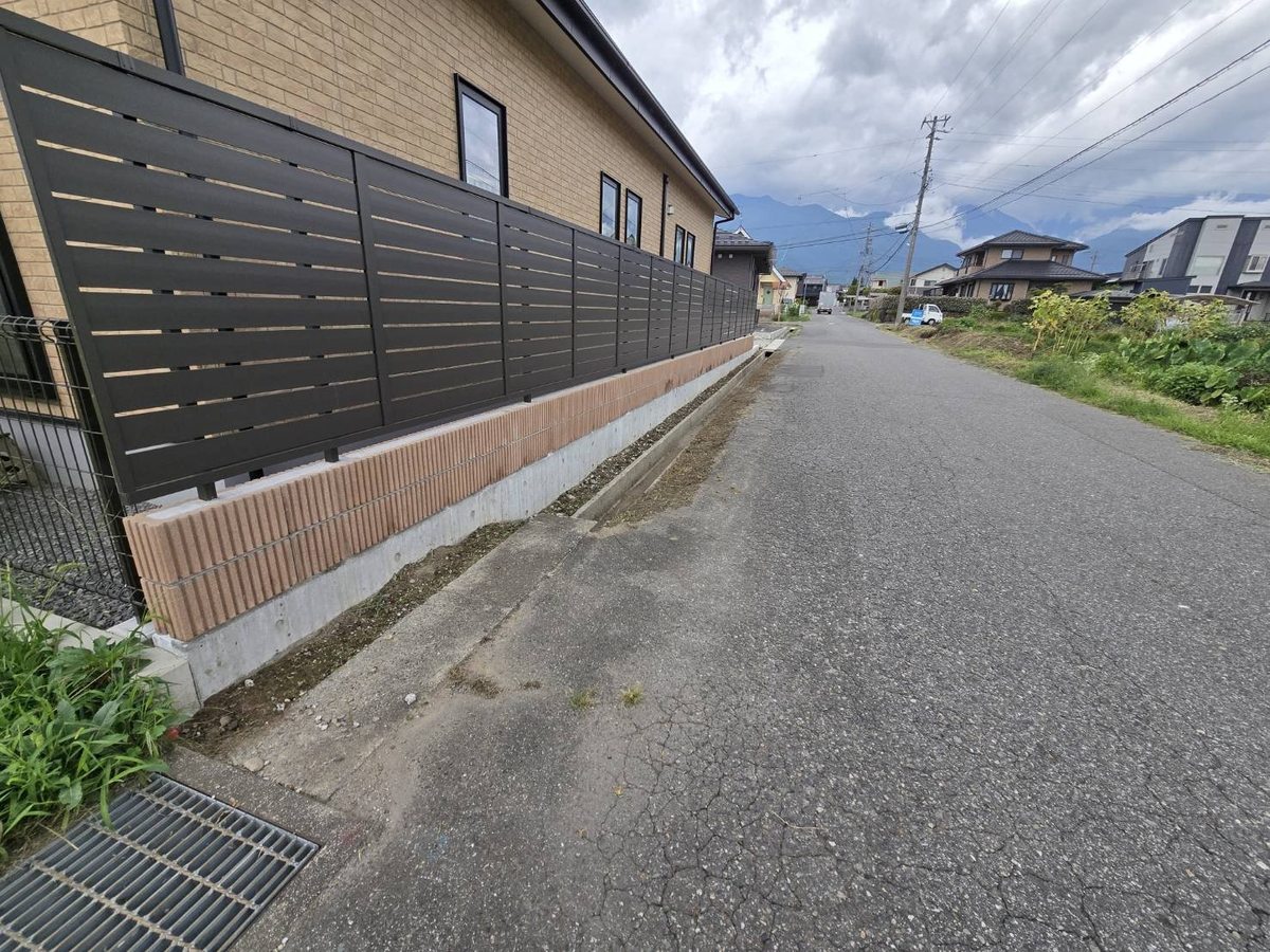 駒ヶ根市の道路縁の草刈り後:フェンス基礎まですっきり見える状態